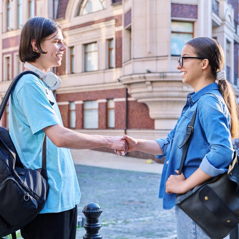 Teenage friends male and female talking on the street of city